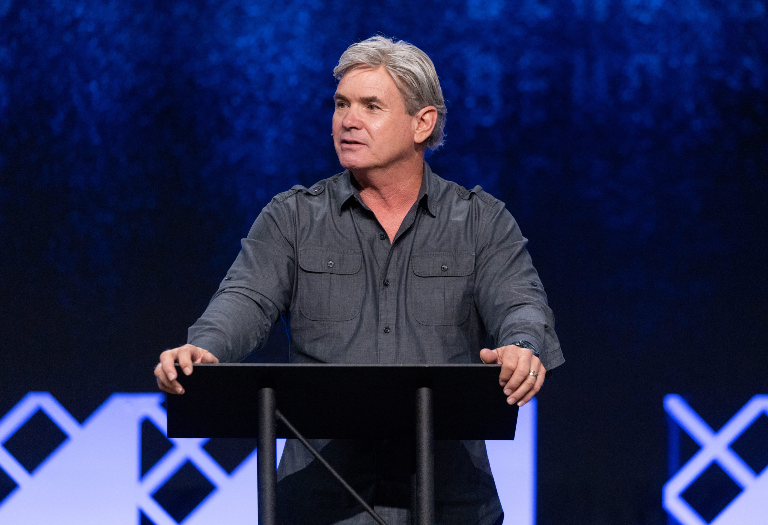 Man speaking at a podium during a conference - signs of the rapture