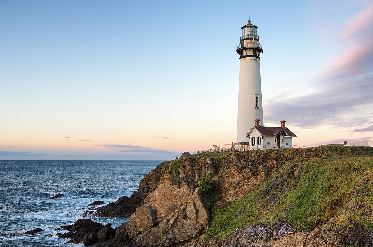 Lighthouse on a rocky coastline at sunset - do christians go through the tribulation
